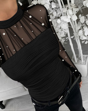 Top texturizado de corte entallado, con cuello alto simulado, detalles de perlas, malla transparente, frunces y espalda calada