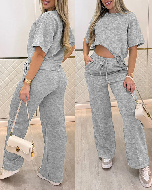 Conjunto casual de dos piezas con top de manga corta, cuello redondo y abertura lateral, y pantalones de pierna ancha con cordón, cintura elástica y costura delantera
